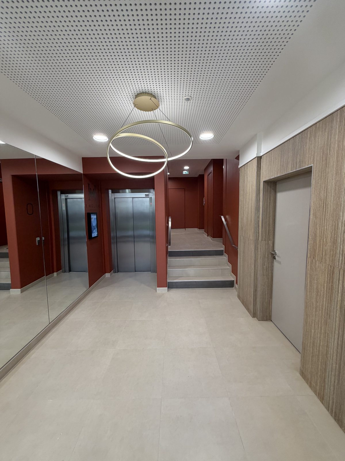 Hall avec lustre design et acc&egrave;s ascenseur